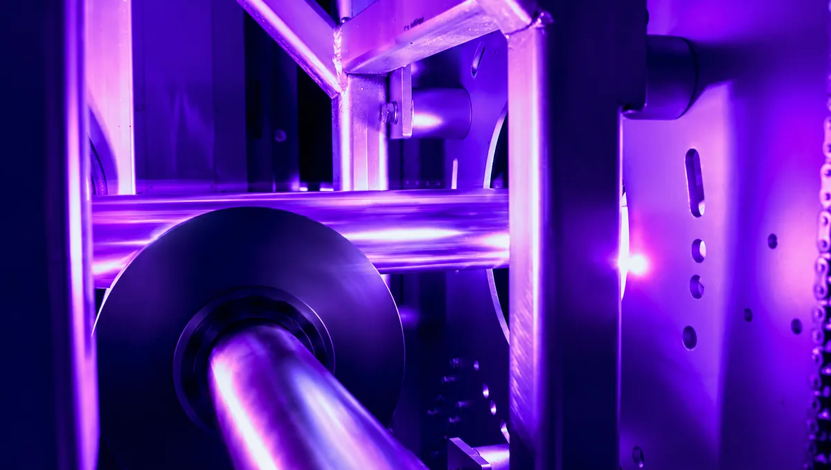 Tube passing under UV lamps in a curing chamber