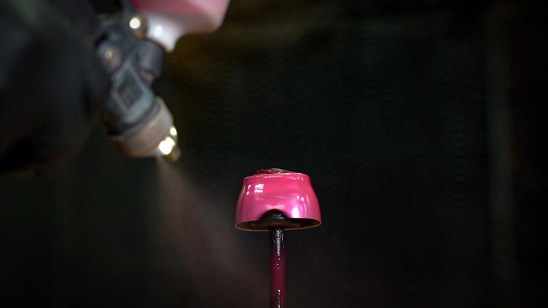 metal item being coated with a spray gun